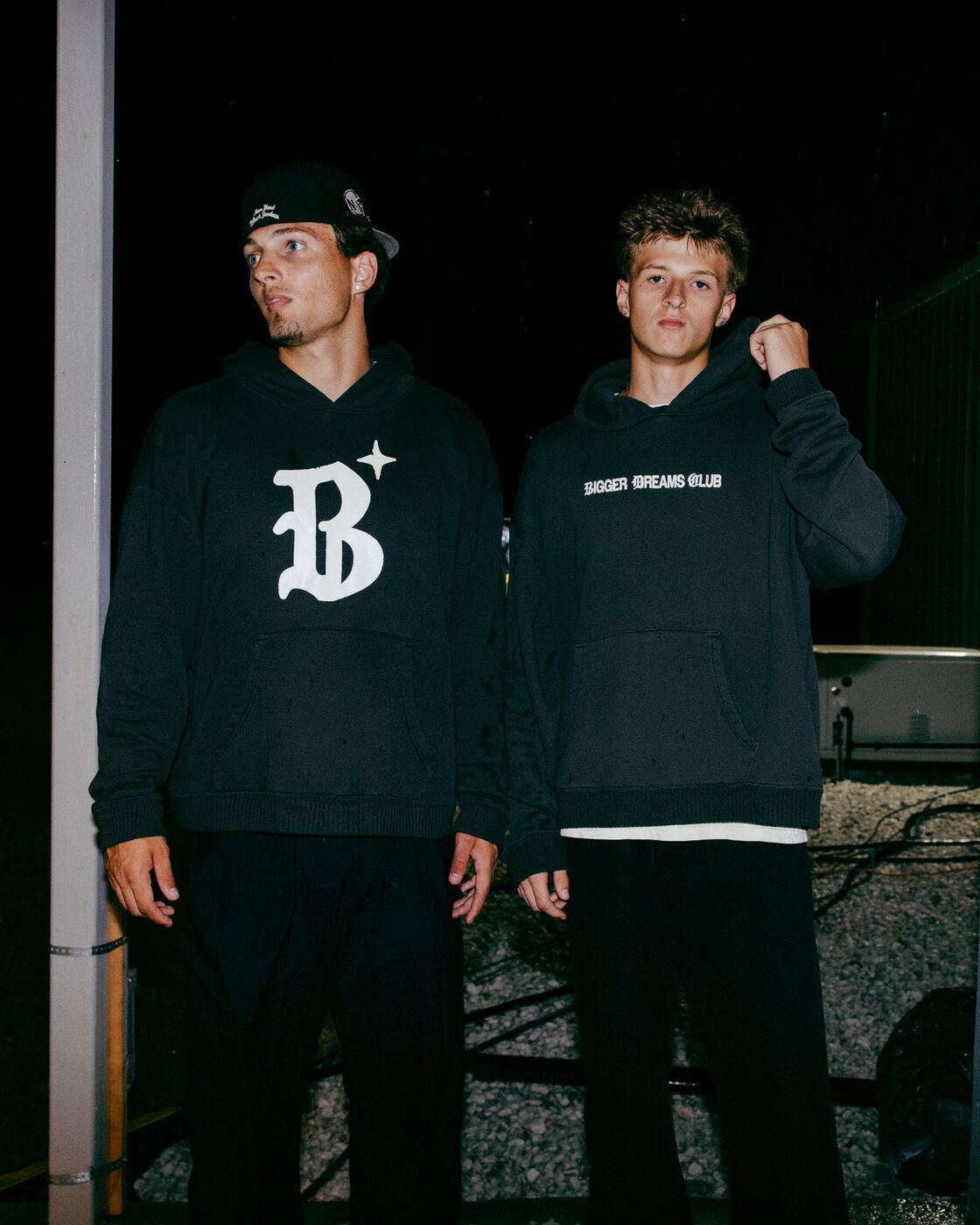 Two people wearing Bigger Dreams Club hoodies
